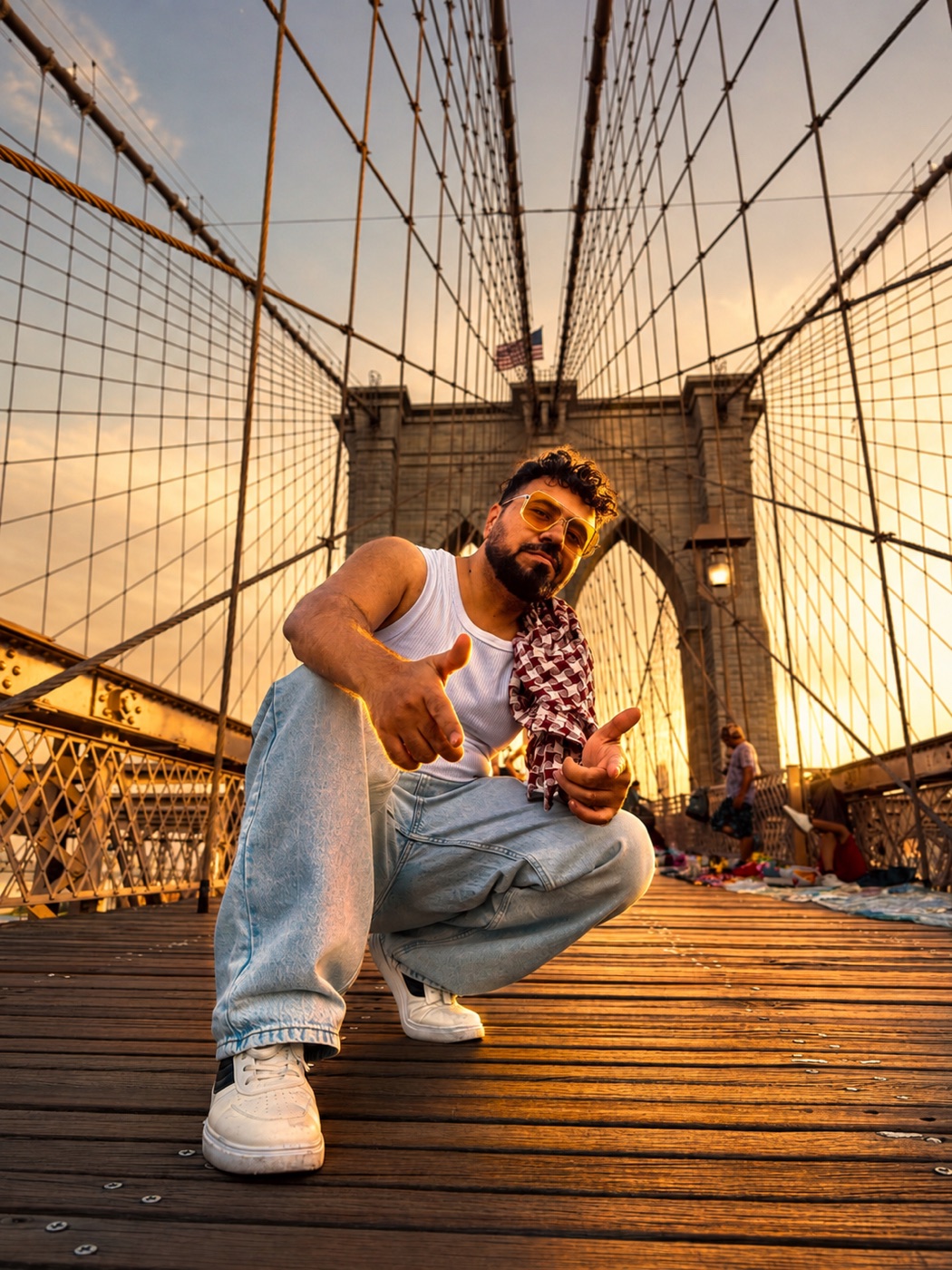 Mobeen Akhtar crouching for a photo on the Brooklyn Bridge, New York
